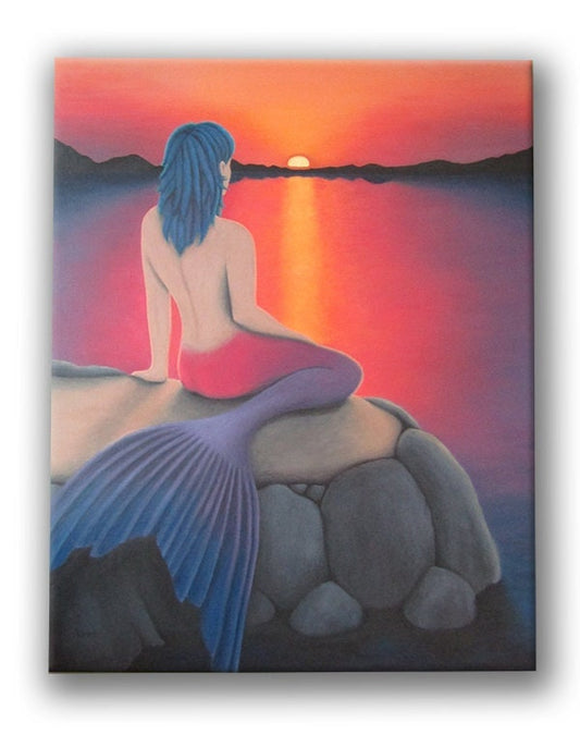 Mermaid sitting on an outcropping of rocks, watching the sunset over the water, with mountains in the background.